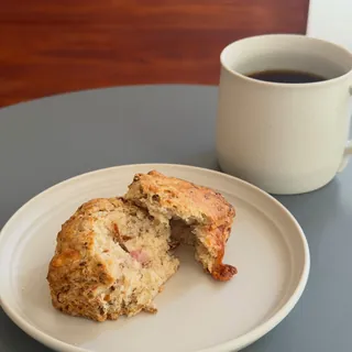 Instagram post: a ham and cheese scone broken open, next to a mug of coffee